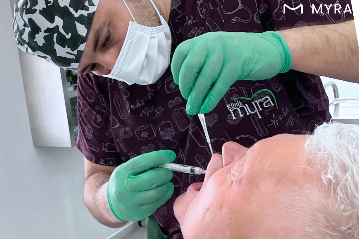 Diş hekimi tarafından lokal anestezi uygulanan hasta