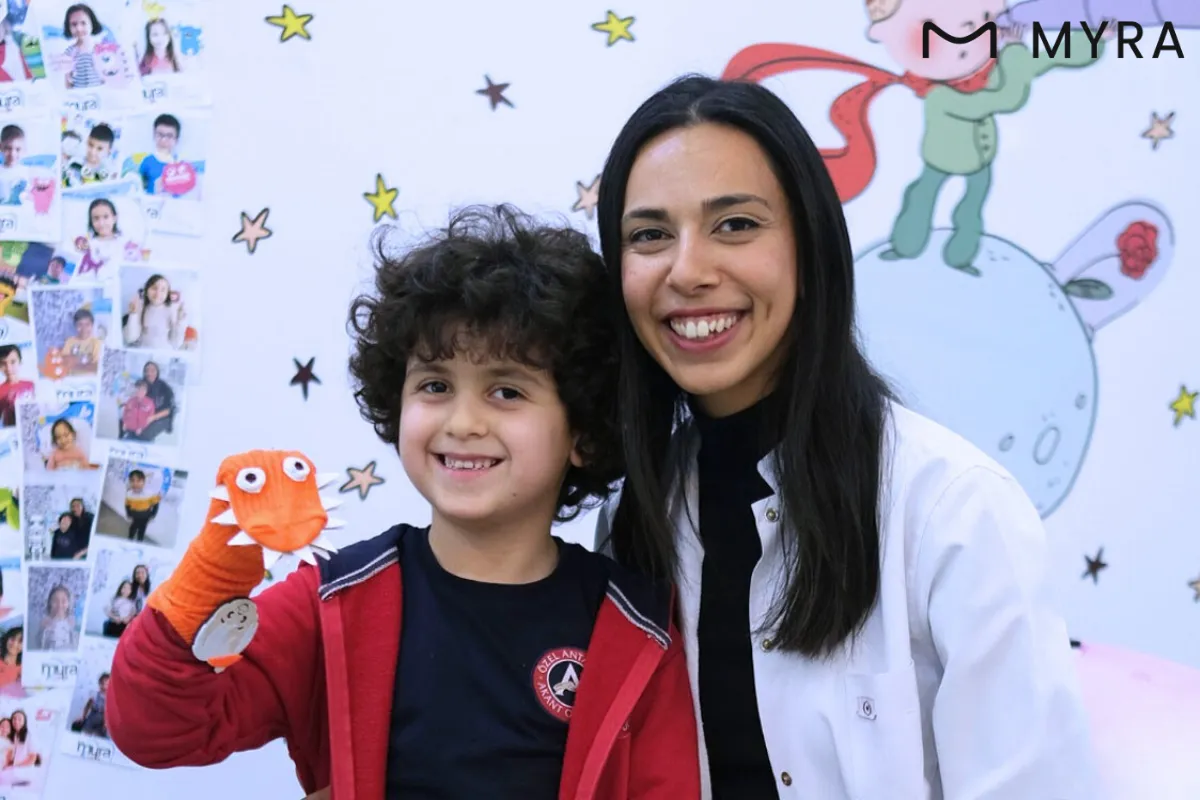 Özel ihtiyaçları olan çocukla birlikte poz veren pedodonti uzmanı